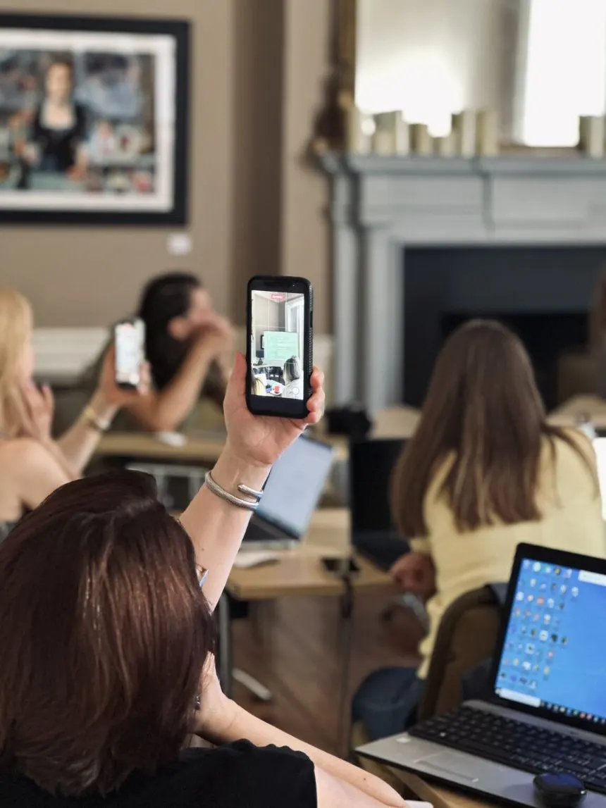 Members holding their phones up to photograph the screen during a Zorya AI session