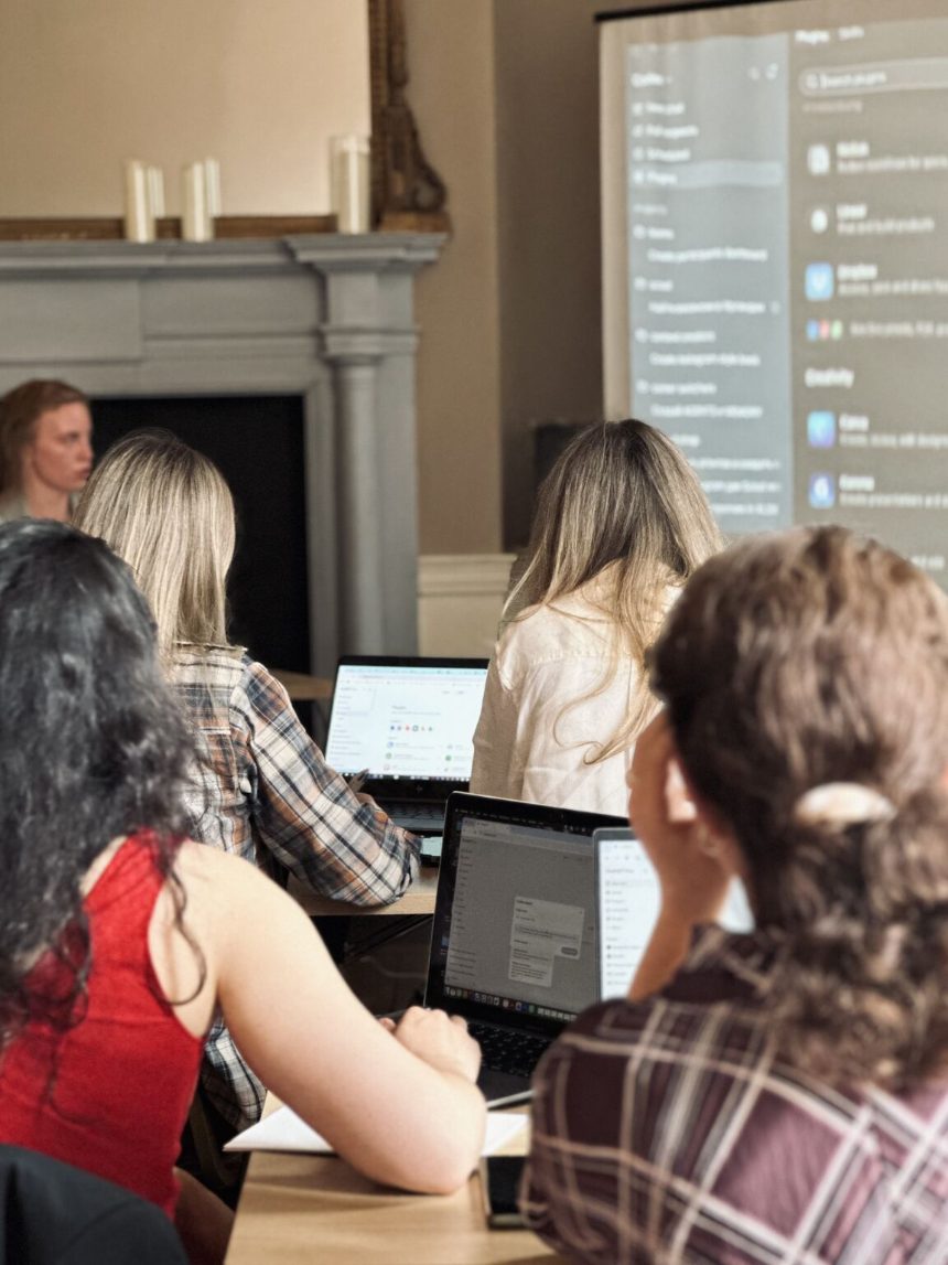 A row of members at laptops following a live walkthrough on the projected screen