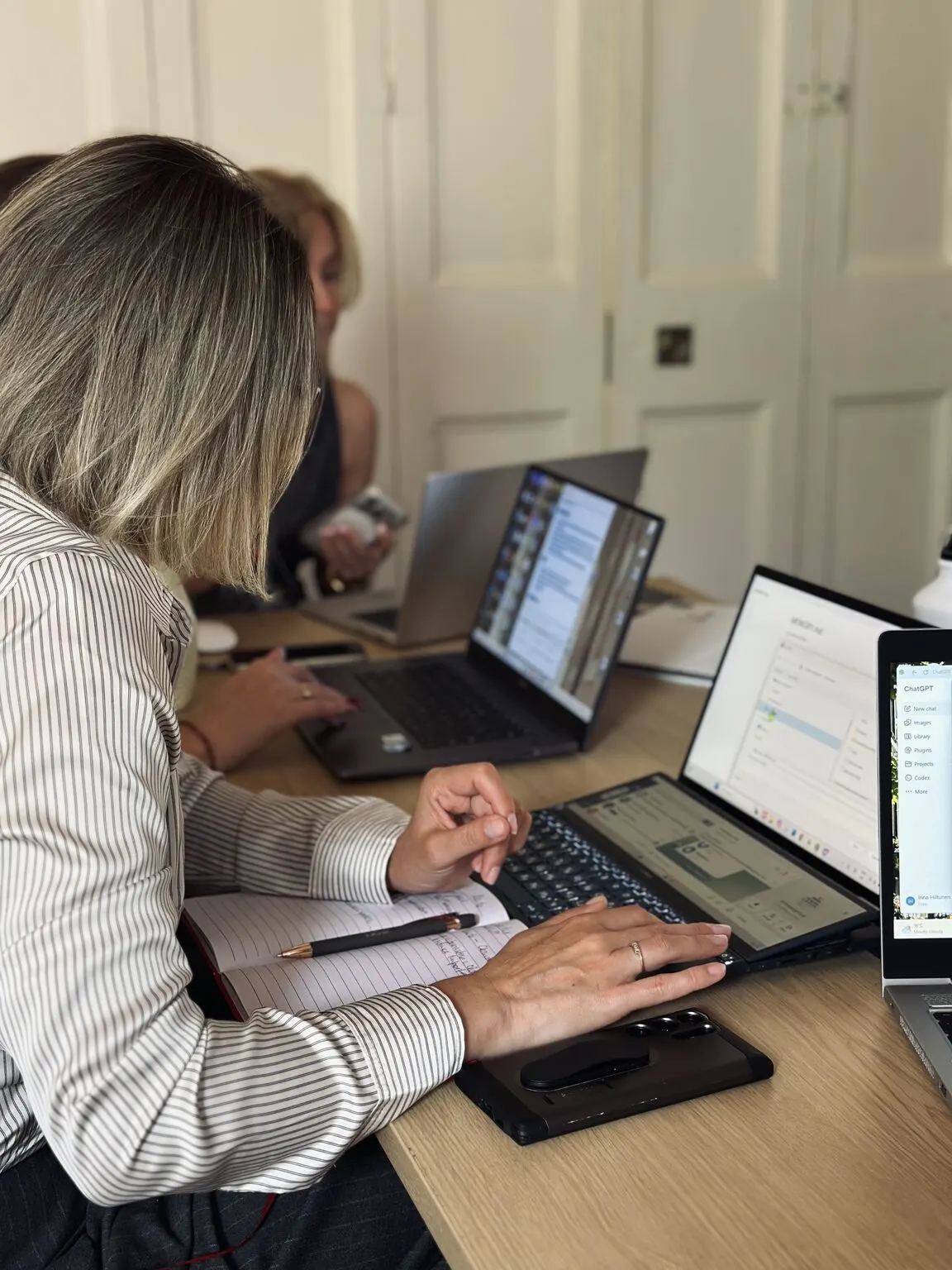 Members working on laptops together during a Zorya AI event